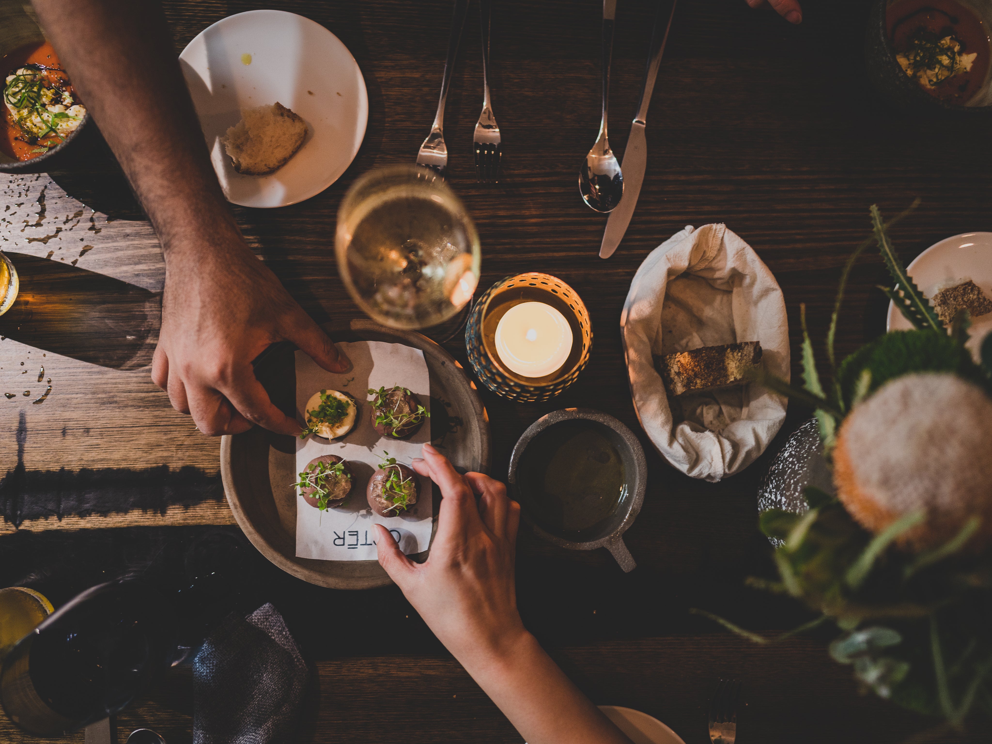 Bovenaanzicht van een tafel met wijn en hapjes om te delen – gezellig foodpairingmoment met Vineur-wijn